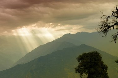 Rabangla, Sikkim, Hindistan 'dan gelen güneş ışınları. Ön planda Slihoutte ağaçları ve arka planda Himalaya dağları. Sikkim 'li Büyük Himalayalar' ın muhteşem manzarası..