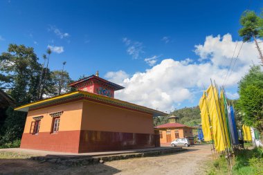 Sikkim, Hindistan 'daki Okhrey Köyü' nde güneşli bir Budist Manastırı. Yukarıda mavi bulutlu gökyüzü ve arkada Himalaya Dağları.
