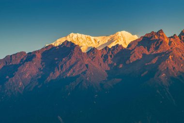 Dünya 'nın üçüncü en yüksek dağı olan Kangchenjunga, Himalaya' nın Sikkim, Hindistan 'dan güneye uzanan Kabru Dağı' nda güneşin doğuşunun güzel ilk ışığı. Nepal Hindistan sınırı.
