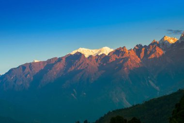 Dünya 'nın üçüncü en yüksek dağı olan Kangchenjunga, Himalaya' nın Sikkim, Hindistan 'dan güneye uzanan Kabru Dağı' nda güneşin doğuşunun güzel ilk ışığı. Nepal Hindistan sınırı.