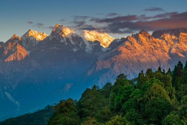 Kanchenjugha Dağı, Himalaya sıradağları, Sikkim, Hindistan 'da güneşin doğuşundan güzel bir gün ışığı. Şafak vakti dağlarda turuncu renkler