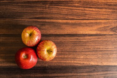 Ripe red color apples kept on a wooden table with copy space 