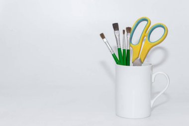 Boya fırçaları beyaz arkaplan ve kopyalama alanı olan bir kapta durmaya devam etti