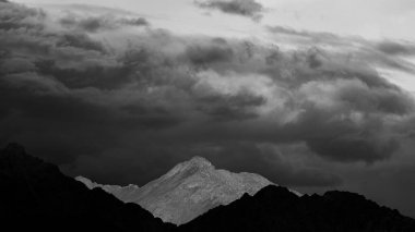Dağların siluetlerinin ve tek renkli bulutların panoramik görüntüsü   