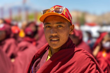 Leh 'li genç bir Budist rahibin portresi, Ladakh kep ve manastır kırmızısı bir cübbe giyiyor. 23 Mayıs 2024.