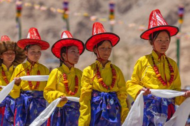 Ladakh 'lı genç kızlar 23 Mayıs 2024' te Leh, Ladakh Hindistan 'da geleneksel kostüm ve şapkalarını giyip dans ediyorlar..
