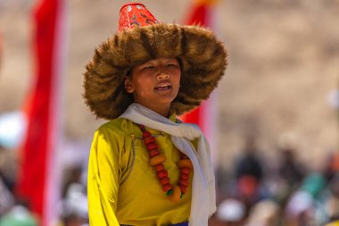 23 Mayıs 2024 'te Leh, Ladakh Hindistan' da sarı bir kostüm, beyaz atkı ve şapka giyen genç bir Tibetli kızın portresi.. 