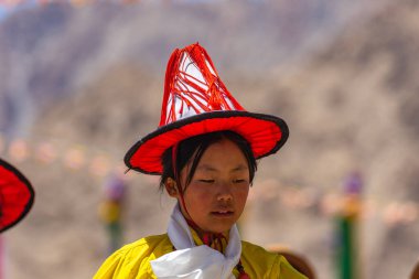 23 Mayıs 2024 'te Leh, Ladakh Hindistan' da sarı bir kostüm, beyaz atkı ve şapka giyen genç bir Tibetli kızın portresi.. 