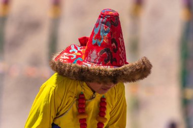 23 Mayıs 2024 'te Leh, Ladakh Hindistan' da sarı bir kostüm ve kürk şapka giyen Tibetli bir çocuğun portresi.. 