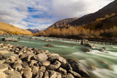 Orta ve ön planda kayalar akan İndus Nehri 'nin güzel manzarası.