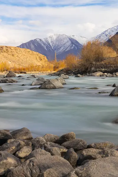 stock image A beautiful landscape of Indus River flowing with rocks in the middle and foreground.