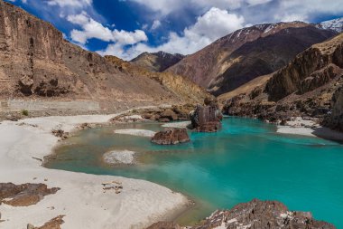 Jagged Dağı 'ndaki kayaların ve Ladakh' taki berrak yeşil suyun ortasındaki kumlu plajların manzarası..