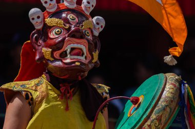 A colorful mask dance and drum beating being performed at Hemis Monastery at Leh, Ladakh India. clipart