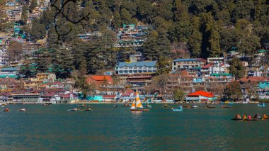 Hindistan 'ın Nainital kentindeki Naini Gölü' nde yelkenli tekneler ve kürek çeken turistlerin manzarası. 2 Ocak 2022 'de tıklandı.