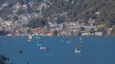 Hindistan 'ın Nainital kentindeki Naini Gölü' nde yelkenli tekneler ve kürek çeken turistlerin panoramik görüntüsü. 2 Ocak 2022 'de tıklandı. 