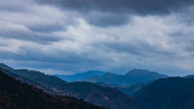 Dağların manzarası ve bulutlu geniş vadiler ve mavi gökyüzü.