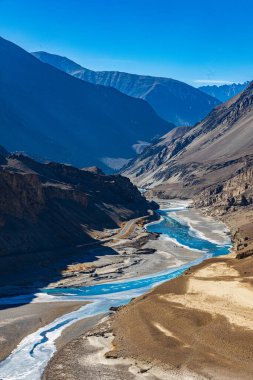 Zanskar Nehri 'nin mavi suları, kışın kenarlarında donarak dağların arasından akar..