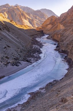 Donmuş Zanskar nehri Ladakh 'ın engebeli dağ sıralarından akıyor..