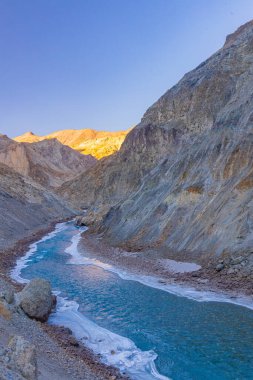Donmuş Zanskar nehri Ladakh 'ın engebeli dağ sıralarından akıyor..