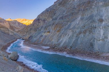 Zanskar Nehri 'nin mavi suları, kışın kenarlarında donarak dağların arasından akar..