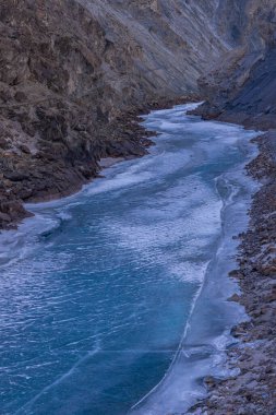 Donmuş Zanskar nehri Ladakh 'ın engebeli dağ sıralarından akıyor..