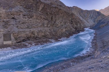 Donmuş Zanskar nehri Ladakh 'ın engebeli dağ sıralarından akıyor..