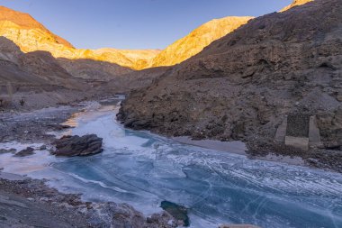Donmuş Zanskar nehri Ladakh 'ın engebeli dağ sıralarından akıyor..