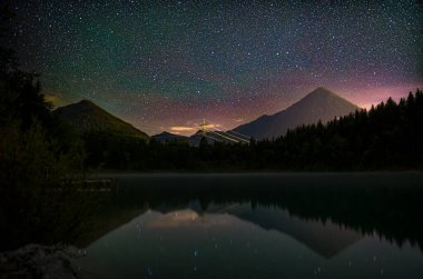 Gece gökyüzü yansıması Urisee Gölü 'nde Alpler arka planda