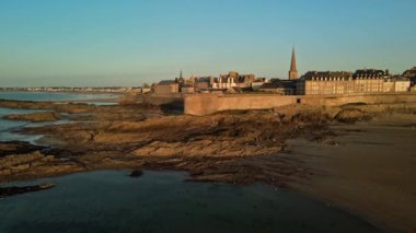 Günbatımında tarihi surlarını ve okyanuslarla beslenen havuzunu gözler önüne seren güçlendirilmiş kasaba Saint-Malo 'nun hava manzarası. Canlı günbatımı renkleri suyu yansıtıyor ve dingin bir ortam yaratıyor..