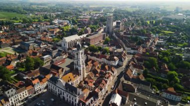 Kırmızı kiremitli çatıları, UNESCO listesindeki çan kulesi, barok Cizvit şapeli ve gotik Saint-Pierre kilisesi olan tarihi bir Fransız kasabasının insansız hava aracı görüntüsü. Aire-sur-la-lys 'de çekilen