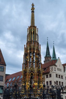 NUREMBERG, ALMANY - 22 Kasım 2022: güzel Schoner Brunnen çeşmesi bulutlu bir günde. Almanya 'nın Nuremberg kentindeki Hauptmarkt meydanında yer almaktadır.