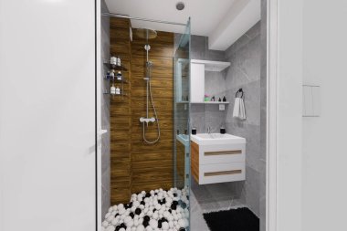 Küçük bir banyo için modern minimalist tasarım. Doğal siyah ve beyaz renkler ve ahşap benzeri malzemeler kullanarak..
