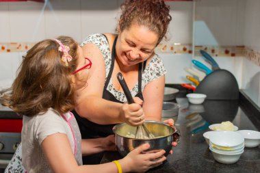 Anne ve kızı mutfakta yemek yaparken mutlular. Mutluluk anı..
