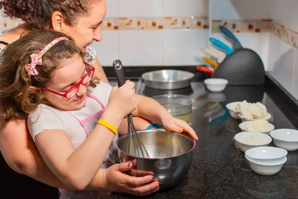 Anne ve kızı mutfaklarında pasta yaparken şefkatle oynuyorlar..