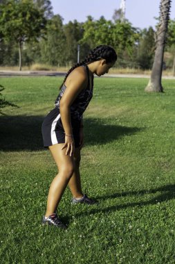 Kız dışarıda bacak esneme egzersizi yapıyor. Odaklanma arkaplanı.