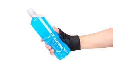 Plastic bottle with blue isotonic drink in male hand isolated on white background.