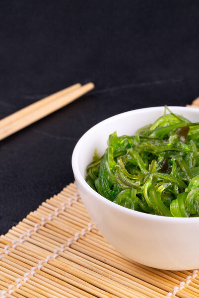 White plate with chuka seaweed close-up on a dark background