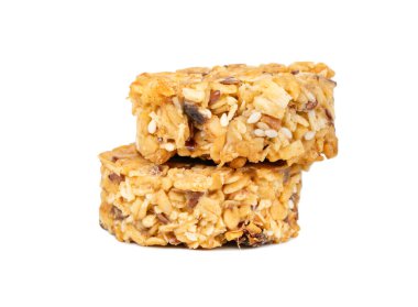 Sağlıklı mısır gevreği ve bal taneleriyle dolu iki tahıllı kurabiye beyaz arka planda izole edilmiş.