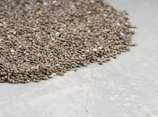 stock image Scattered chia seeds close up on concrete background