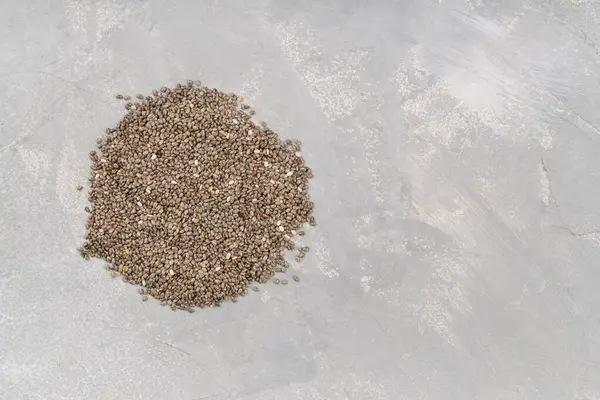 stock image Heap of chia seeds on concrete background, top view. Copyspace