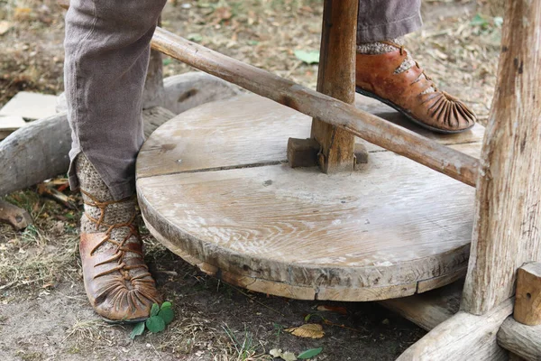 stock image a man sits on a bench and turns the potter's wheel