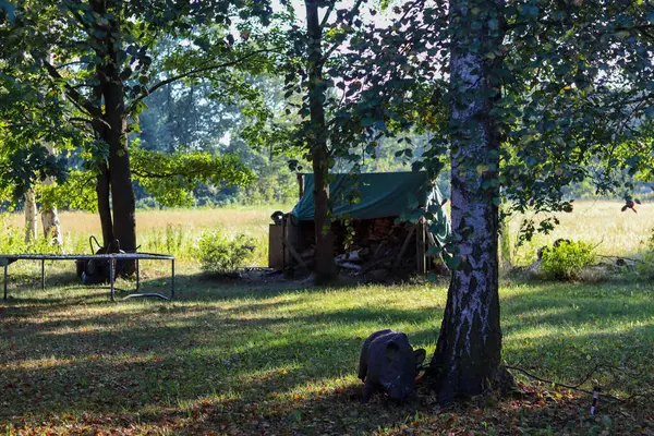 Eski kırsal ahşap masa ve ormanda çadırı olan bir sandalye.
