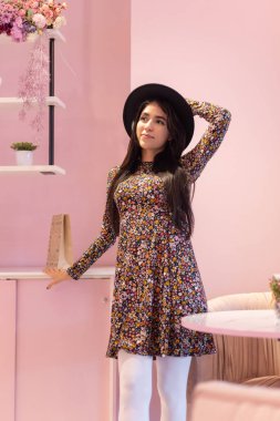 Aksesuar olarak siyah şapka takan ve hayvan desenli elbise, moda ve doğal güzellik giyen uzun düz saçlı güzel bir kadın.