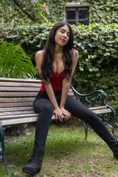 young latin woman with long straight hair sitting posing, natural beauty and fashion, model portrait wearing low cut blouse