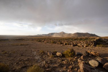 Dağlar ve gökyüzü arasındaki ufkun heybetli duvar kâğıdı bulutlarla zemin kayalarla yer, manzara ve gün ışığı.