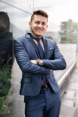 Kısa saçlı, zarif genç bir iş adamının portresi mavi bir takım elbise ve kravat giyer.