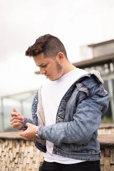 jean jacket details and young latin man wear short hair, attractive male model, fashion and beauty, city background