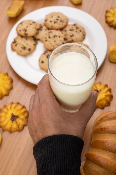 Оформление Стола Сладким Печеньем Рукой Держа Стакан Молока Завтрак Студии — стоковое фото
