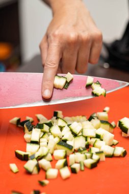 Mutfak bıçağı, sağlıklı yemek hazırlığı, mutfak gereçleri ve profesyonel şef mesleği ile bir kabağın karesini keser.