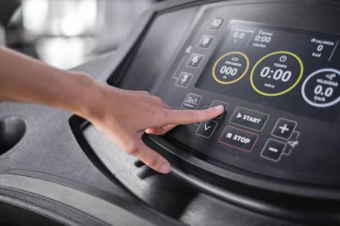 Koşu bandının kontrol panelinin tuşlarına basma ayrıntıları, kardiyo için spor makineleri, nesneler ve modern tasarım ile teknoloji